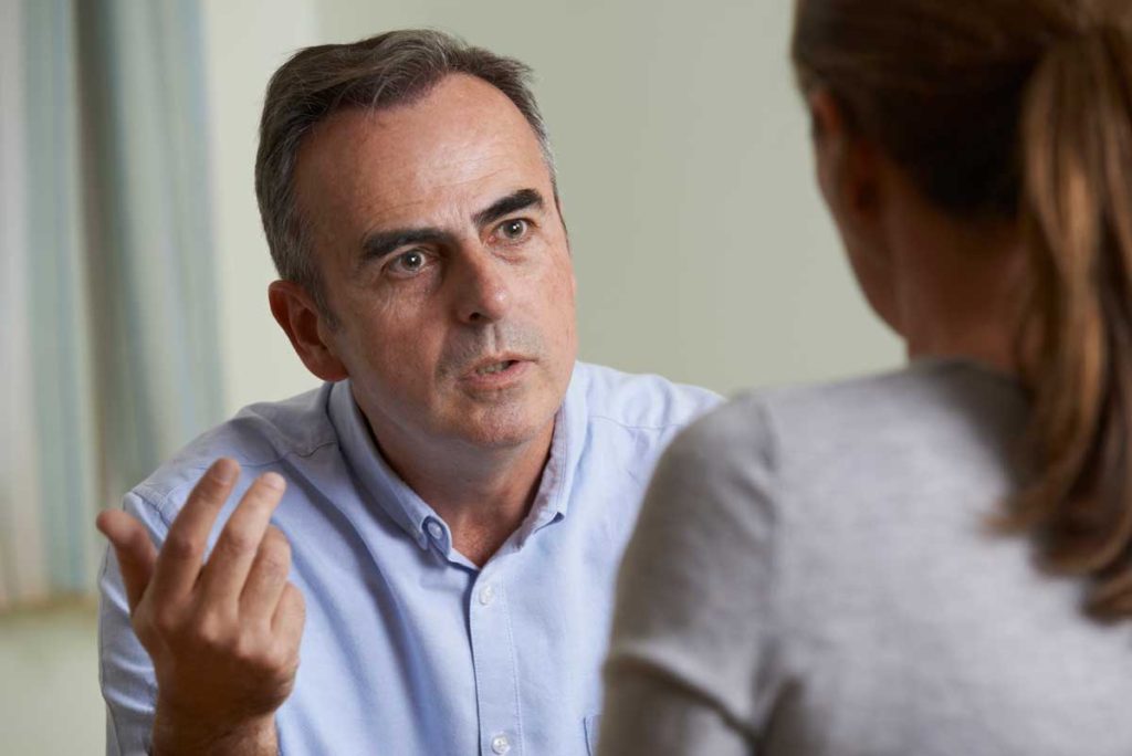 Photo of anxious man in conversation with a woman